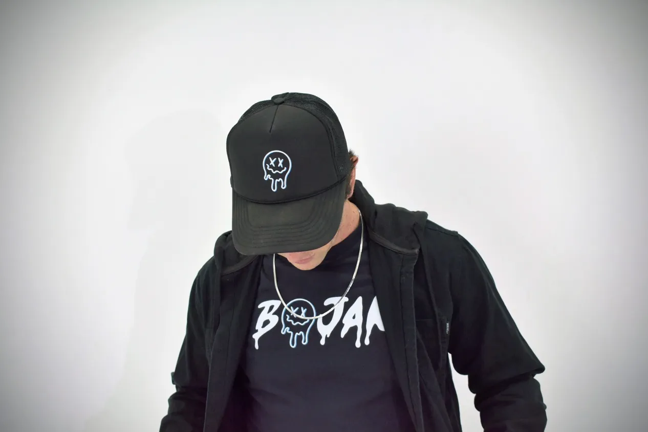 BOJAK looking down in BOJAK apparel with a jacket and chain