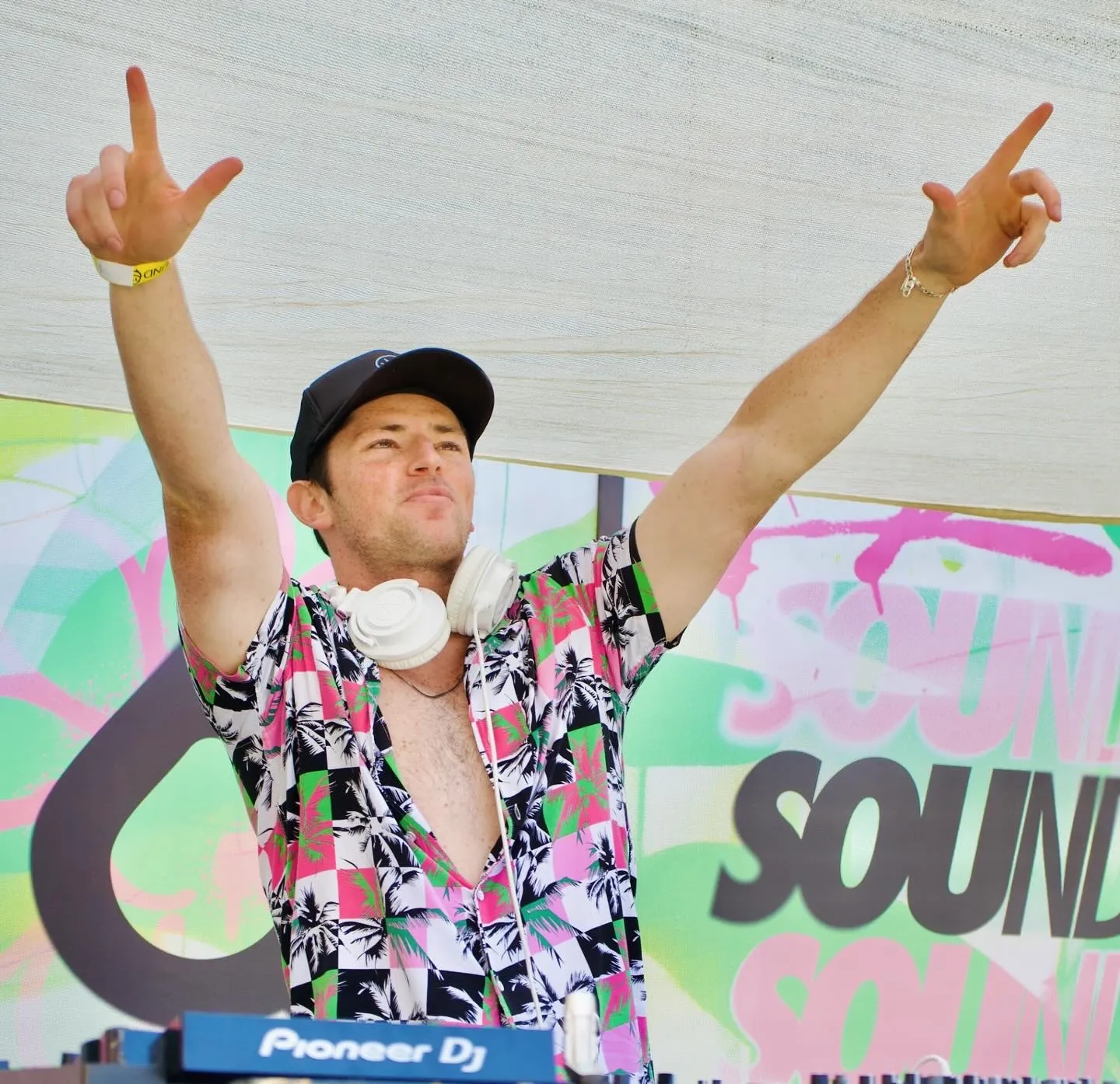BOJAK performing with arms raised at a daytime event